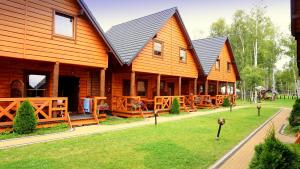 a group of wooden houses with a yard at Ferienhäuser RAJ - STAR - BOBOLIN in Bobolin