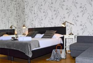 ローマにあるBlue Star luxury apartment San Giovanni - Colosseoのベッドルーム1室(ベッド1台、ソファ、椅子付)