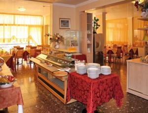 a kitchen with a table with plates on top of it at Hotel Paron in Bibione