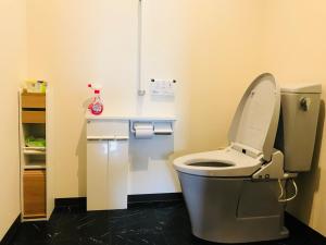 La salle de bains est pourvue de toilettes avec un couvercle. dans l'établissement NARA japanese garden villa, à Nara