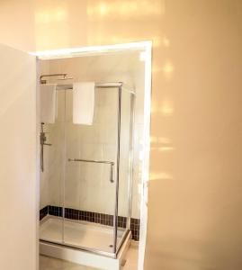 a shower with a glass door in a bathroom at LinT Guest House in Gaborone