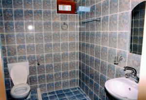 a blue tiled bathroom with a toilet and a sink at Gerdjika Hotel in Nesebar +19 photos
