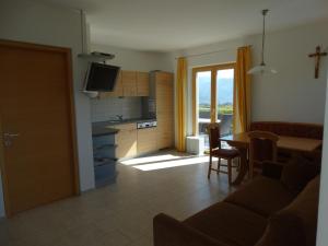 sala de estar con cocina y mesa de comedor en Fasslhof, en Cornaiano