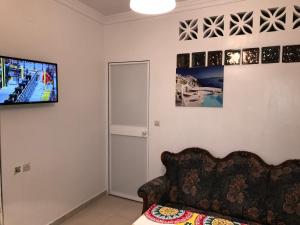 a living room with a couch and a tv on the wall at Residencial Puro Mediterraneo in Ceuta