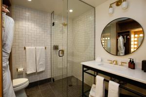 a bathroom with a toilet, sink, and shower stall at The Ramble Hotel in Denver
