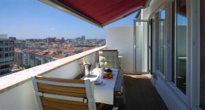 a balcony with a table and a view of a city at Quad Avenue in Lisbon