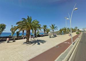 uma rua com palmeiras e pessoas na praia em Casa Aray em Tías