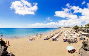 a beach with a lot of people and the ocean at Casa Aray in Tías