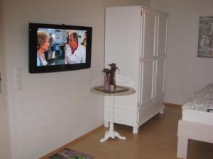 sala de estar con TV colgada en la pared en Ferienhaus Wattenhus, en Büsum
