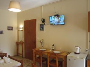 a kitchen with a table and a television on the wall at Dimitra appartements in Argostoli