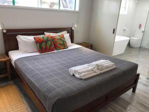 a bedroom with a bed with towels on it at Port Douglas Penthouse Suite in Port Douglas