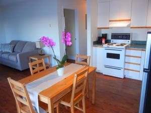 una cocina y una sala de estar con una mesa con un jarrón de flores en Shores of Deer Lake en South River