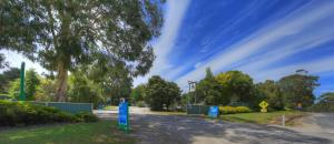 a road in a park with trees and a blue sky at Toora Tourist Park in Toora