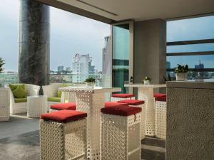 a balcony with tables and chairs with a view of the city at Pullman Saigon Centre in Ho Chi Minh City