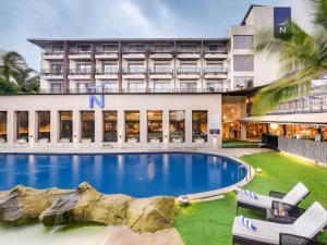 坎多林Novotel Goa Candolim的酒店楼前有一座大型游泳池