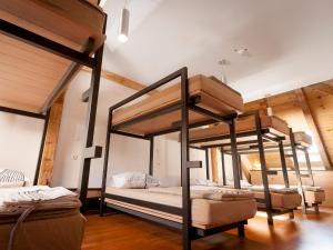 two bunk beds in a room with wooden ceilings at Hostel Situla in Novo Mesto