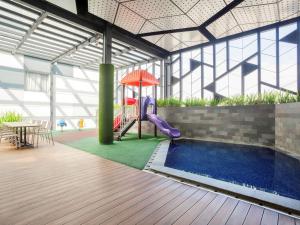 einen Spielplatz in einem Gebäude mit Rutsche und Pool in der Unterkunft Ibis Styles Jakarta Sunter in Jakarta