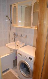 a bathroom with a washing machine and a sink at Pas Virginiją in Nida +10 photos