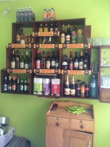 un montón de botellas de alcohol en una pared verde en Suba Motel en Kihihi