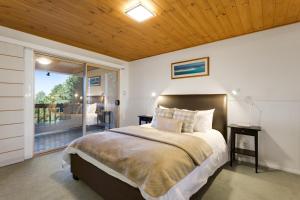 a bedroom with a large bed and a sliding glass door at Ravensbourne Escape - Windsong in Ravensbourne