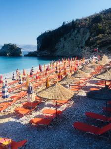 a bunch of umbrellas and chairs on a beach at Sunset House in Ksamil