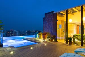 a balcony of a building with a swimming pool at night at Six Seasons Hotel in Dhaka
