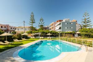 a swimming pool in a resort with buildings in the background at Theros in Rethymno