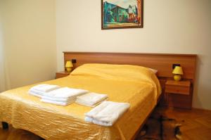 a bedroom with a yellow bed with towels on it at Apartment Branko with free parking in Ičići