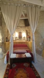 een slaapkamer met 2 bedden in een stenen gebouw bij Troglodyte loft in Thoré-la-Rochette