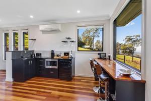 a kitchen with black and white appliances and a large window at Tranquillity at Ravensbourne Escape in Ravensbourne