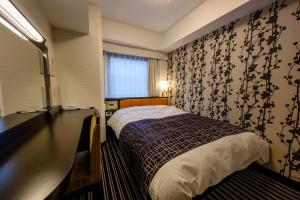 a small bedroom with a bed and a window at APA Hotel TKP Keikyu Kawasaki Ekimae in Kawasaki