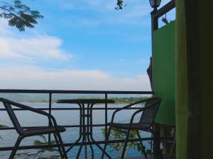 2 sillas y una mesa en un porche con vistas al agua en Green River Hill Resort, en Si Sawat
