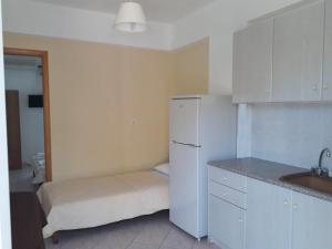 kuchnia z białą lodówką i zlewem w obiekcie Almirikia Apartments w mieście Mourteri +37 zdjęć