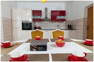 een keuken met een tafel met rode fruitschalen erop bij Large apartment between Split and Trogir in Kaštela