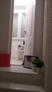 an open door with a book on a window sill with plants at City Square Apartment in Poreč