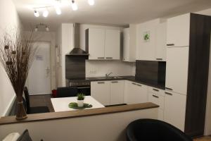 eine Küche mit weißen Schränken und einem Tisch mit Stühlen in der Unterkunft Apartment Sunnseitn in Bad Mitterndorf