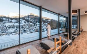 una donna in piedi in una stanza con vista su una montagna di Rainell Dolomites Retreat a Ortisei