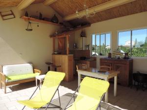 uma sala de estar com cadeiras amarelas e uma mesa em Le Faré Tchanqué Chambre d’hôtes Référence em Cavaillon