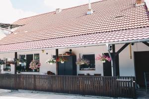 a white house with flowers on the windows and a fence at PaulaApartment&Rooms in Oradea