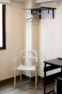 een witte stoel in een kamer met een bureau bij Nana City Hotel in Bangkok