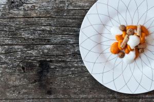 um prato branco de comida numa mesa de madeira em Grottnerhof em Fiè