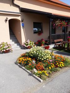 a flower garden in front of a building at Guest House Vana in Korenica