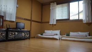 a room with two beds and a flat screen tv at Haengjin Guesthouse in Jeonju