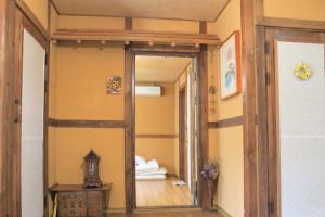 a hallway with a mirror and a room with a bed at Haengjin Guesthouse in Jeonju