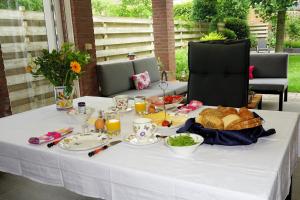 un tavolo bianco con un piatto di cibo sopra di Droomzzz a Herkenbosch