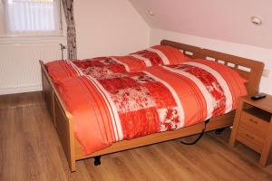 un letto con piumone rosso e bianco e una scrivania di Droomzzz a Herkenbosch