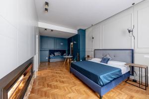 a bedroom with a blue bed and a fireplace at Blue Inn Luxury Suites in Rome