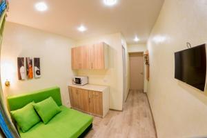 ブラゴヴェシチェンスクにあるSweet Homeのリビングルーム(緑のソファ、テレビ付)