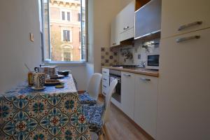 a kitchen with a table with a tablecloth on it at BDC - Maison Sophie al Vaticano in Rome