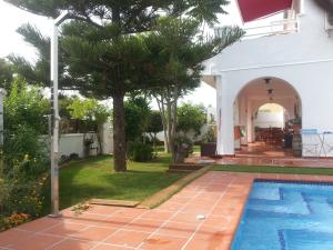 a villa with a swimming pool and a yard at Villa Habana in El Vendrell